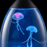 Primer plano de las dos medusas de silicona dentro del agua azul: la de arriba con el domo rosado, la de abajo azul pálida.